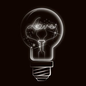 Heart shape inside a light bulb on a black background with the word love written inside. Love of God concept. - Illustration