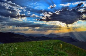 Majestic mountains landscape under sun rays piercing clouds. Peace of God concept.