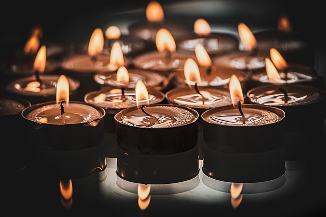 A dark backdrop lit with tea candles. Concept what is Spiritual Awakening in Christianity.