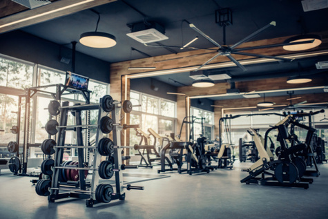 A modern fitness center featuring a variety of sports equipment, including a range of weights on a rack. Concept, Exercise Your Faith.