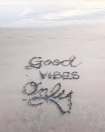 A message on the sand on a beach says, "Good Vibes Only." Concept, self-care motivational speakers.