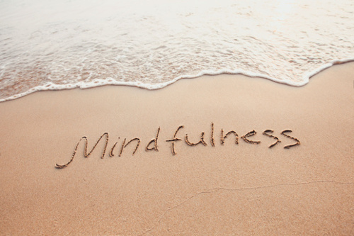 The word "Mindfulness" is written on the sand at a beach. Concept, Mindfulness is a superpower.