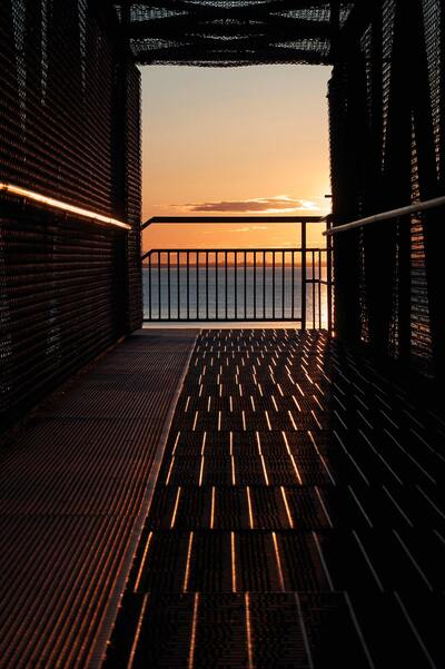 An open-door hallway revealing a breathtaking sunset with an ocean view. Concept, spreading positivity.