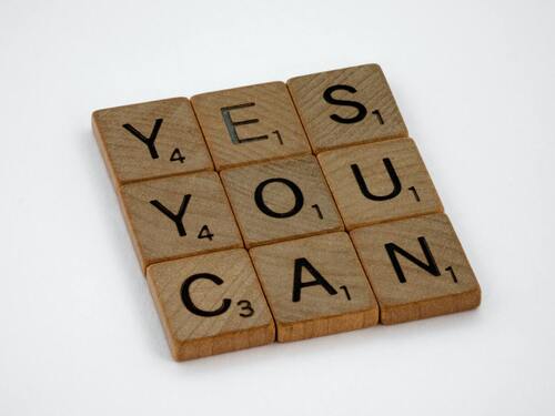 A phrase written on scrabble tiles that say, "Yes, you can." Concept, spreading positivity.